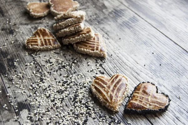 Biscoitos com sementes de gergelim foram espalhados sobre a mesa — Fotografia de Stock
