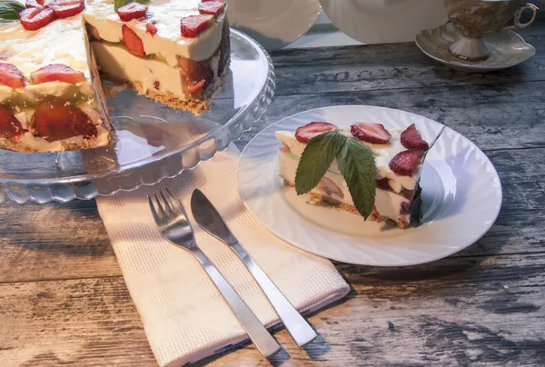 白い皿にイチゴのケーキのスライスはリネン ナプキン、ナイフとフォークを提供しています — ストック写真