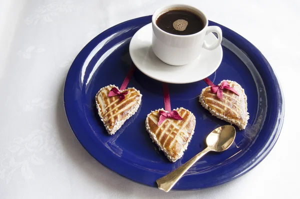 Tre biscotti a forma di cuore sulla piastra blu — Foto Stock