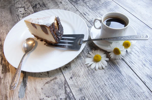 Bit av cheesecake på en vit skål med camomile — Stockfoto