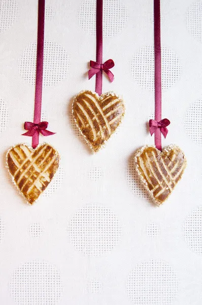三个 cookie 在心的形状与小蝴蝶结的丝带 — 图库照片