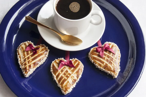 Drei Kekse in Herzform und eine Tasse Cofee — Stockfoto