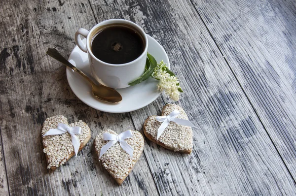 Drei Hochzeitsplätzchen verzierten weißen Sesam mit einer Tasse Kaffee. Retro-Stil. — Stockfoto