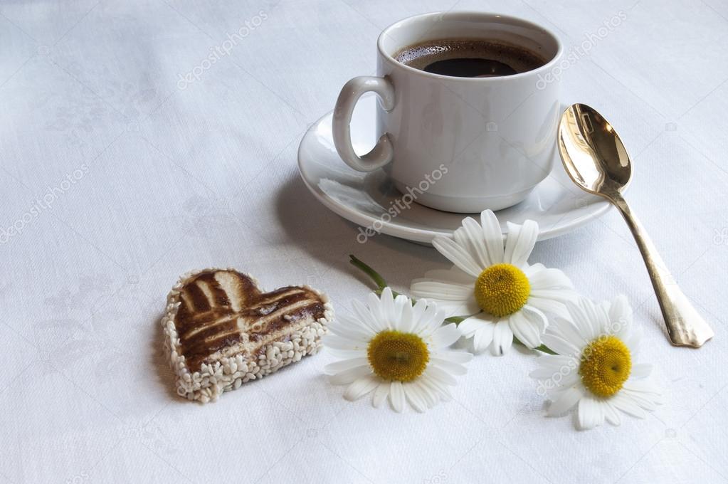 Cookies with a cup of coffee and flowers