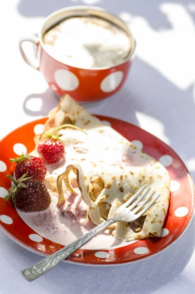 Pancakes with strawberries and sour cream on plate with polka dots — Stock Photo, Image