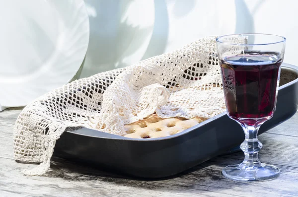 Tarta de cereza casera con un paño de punto y una copa de vino . — Foto de Stock