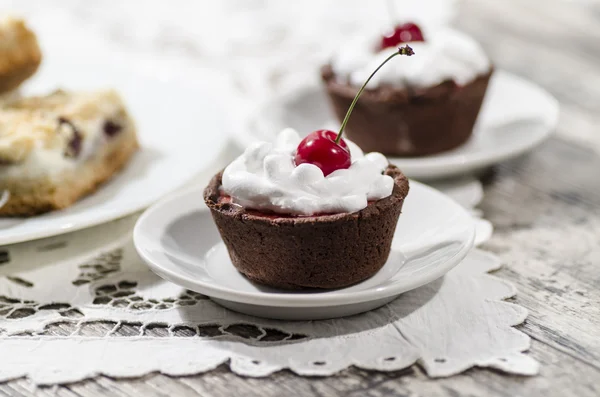 Chocolate dessert with whipped cream and a cherry — Stock Photo, Image