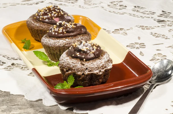 Diet chocolate cupcakes on yeliow rectangular plate with spoon — Stock Photo, Image