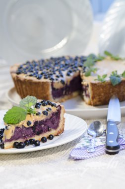 Slice of blueberry pie with mint served with knife and spoon clipart