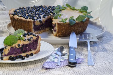 Slice of blueberry pie with mint served with knife and paddle for cake clipart