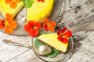 cam levha üzerine taze çiçeklerle süslenmiş kabak cheesecake