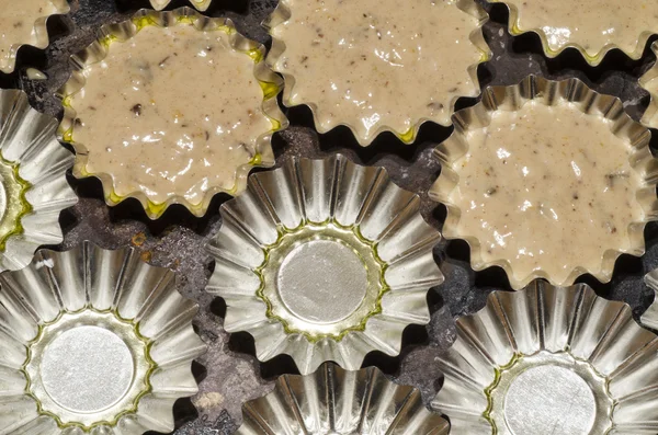 カップケーキを焼くためのアルミニウム金型充填生地 — ストック写真
