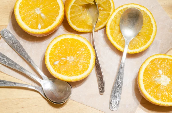 Arance e cucchiaini su carta da forno — Foto Stock