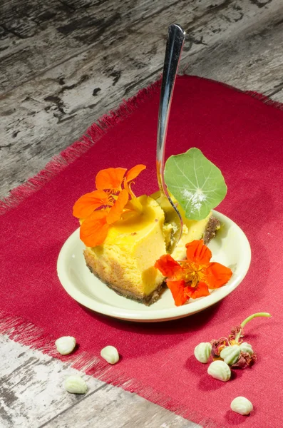 Scheibe Kürbis-Käsekuchen mit Blumen dekoriert — Stockfoto