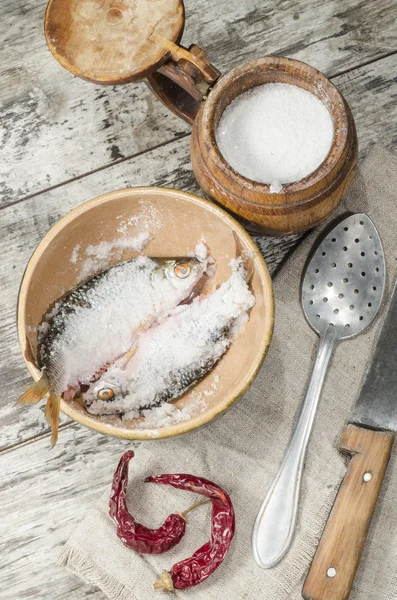 Two roaches fish in ceramic bowl with salt. — Stock Photo, Image