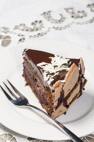 Rebanada de pastel de chocolate decorado con hojuelas de chocolate blanco —  Fotos de Stock