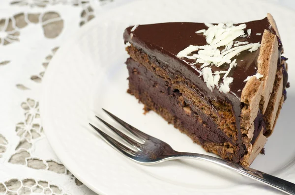 Slice of chocolate cake decorated with white chocolate flakes — Stock Photo, Image