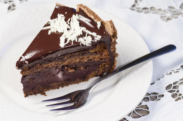 Fetta di torta al cioccolato decorata con fiocchi di cioccolato bianco — Foto Stock