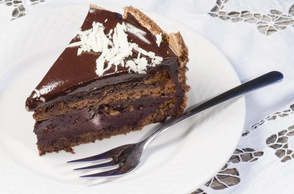 Scheibe Schokoladenkuchen mit weißen Schokoladenflocken verziert — Stockfoto
