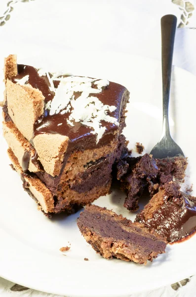 Кусок шоколадного торта, украшенный хлопьями белого шоколада — стоковое фото