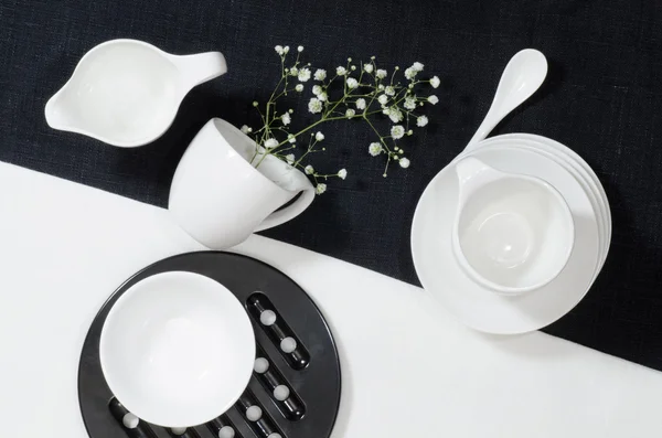 Porcelana branca em toalhas de mesa de linho preto e branco . — Fotografia de Stock