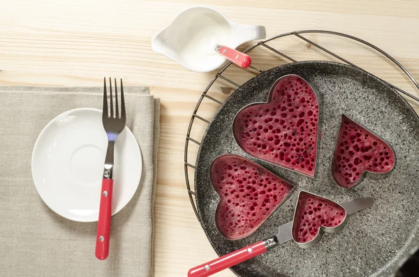 Valentine's Day red pancakes in heart shape with sour cream — Stock Photo, Image
