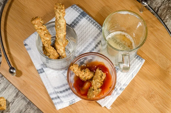 Knoflook kaas brood stokken en cup van bier — Stockfoto