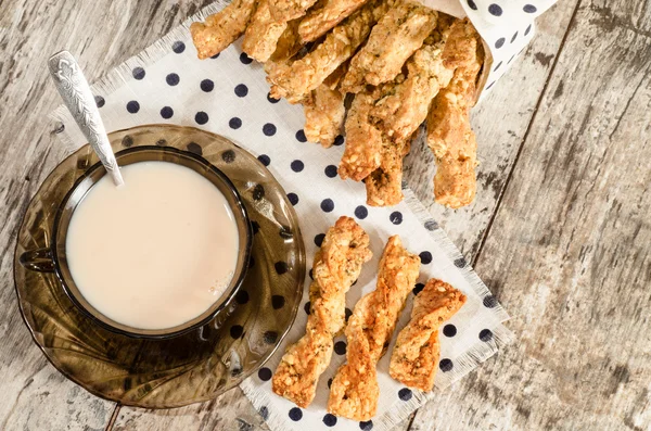 Garlic cheese bread sticks and cup of black tea with milk — Stock Photo, Image