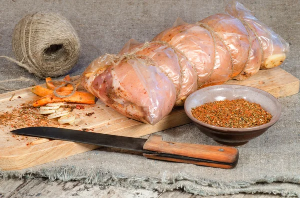 Raw pork roll package for roasting on wooden cutting board