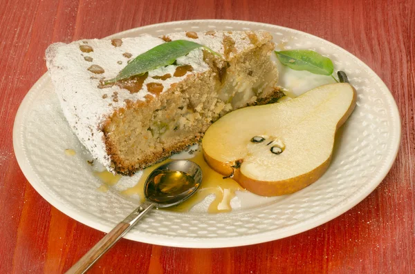 Fatia de torta de pêra com mel na mesa de madeira vermelha — Fotografia de Stock