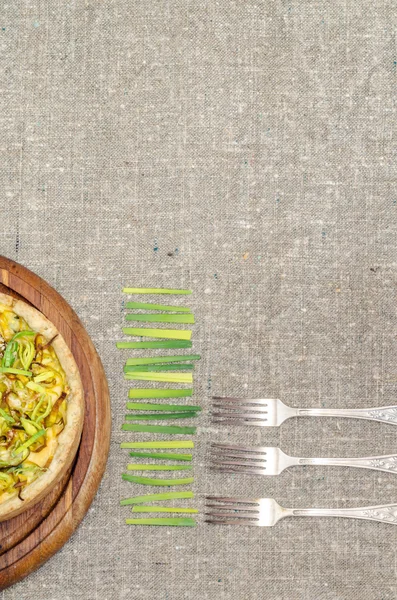 Pie quiche dengan daun bawang, keju di atas taplak meja — Stok Foto