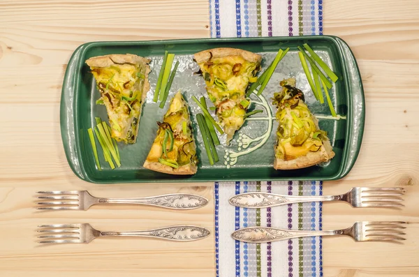 Four pieces of pie with leeks on ceramic plate — Stock Photo, Image