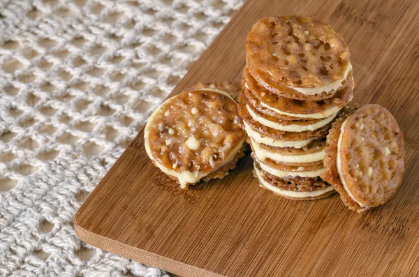Caramel Florentines cookies on a wooden cutting board — Stock Photo, Image