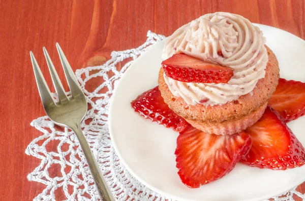 Strawberry cupcake with butter cream decorated with slices of fresh strawberries