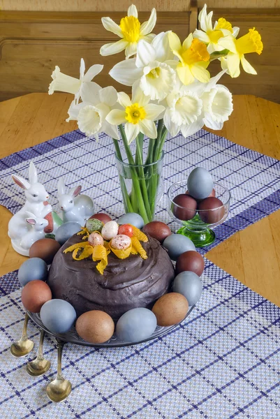 Bayram Paskalya tablo yumurta ve kek renkli çiçeklerle dekore edilmiştir. — Stok fotoğraf
