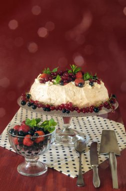 Meringue Cake Pavlova with cream, berries  and mint, bokeh background clipart