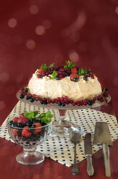 Bolo de merengue Pavlova com creme, bagas e hortelã, fundo bokeh — Fotografia de Stock
