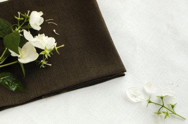 çiçekler ve keten peçeteye Yasemin yaprakları