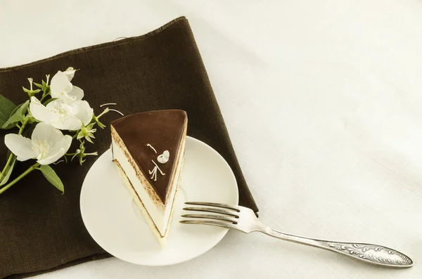 Pièce de gâteau, décorée de fleur de jasmin — Photo
