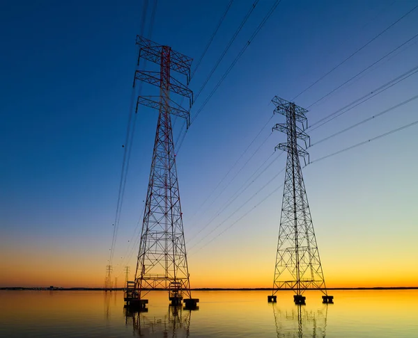 アテネAl付近の夕暮れ時にウィーラー湖を横断する高電圧伝送ライン 日没時に電気パイロン 権力とエネルギー — ストック写真