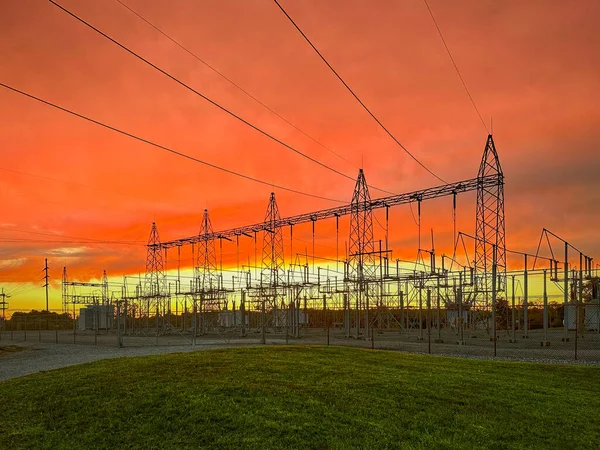 Bright, colorful evening clouds reflect setting sun over a Electric Substation.
