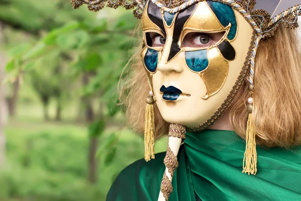Krásná žena v karnevalové masce listoví pozadí — Stock fotografie