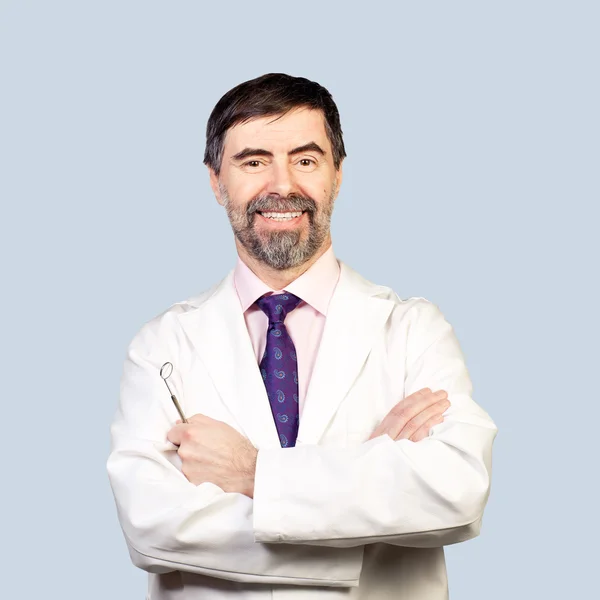 Portrait of happy middle-aged dentist on a pale background, wear — Stock Photo, Image