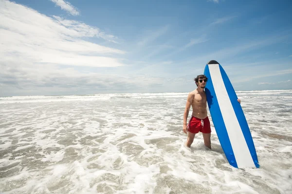 Strong young surf man portrait at the beach with a surfboard. Ba Stock Image
