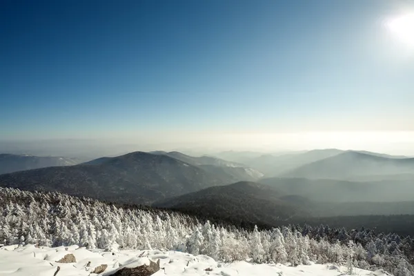 Paesaggio invernale di montagne con neve sotto cielo nuvoloso blu. R — Foto Stock