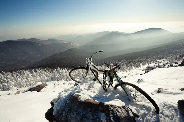Winter landscape of mountains. old bicycle on a mountain top. Ru
