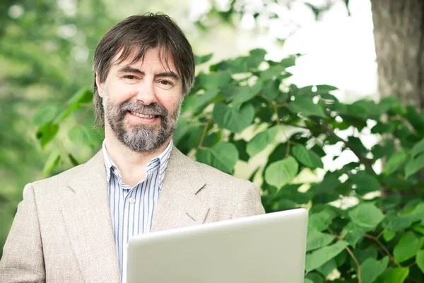 Portrait of happy middle-aged businessman holding notebook and s — Stock Photo, Image