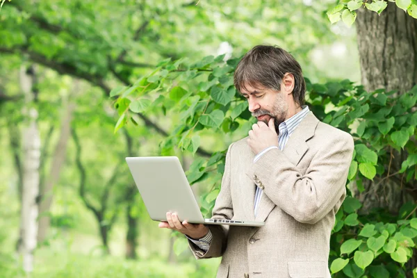 Portrait of happy middle-aged businessman holding notebook and s — Stock Photo, Image