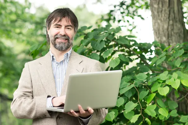 Portrait of happy middle-aged businessman holding notebook and s — Stock Photo, Image