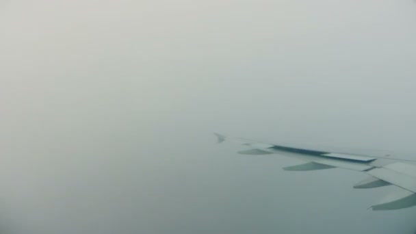 Vista del ala del avión, volando por encima de las nubes, y luego empezando a aterrizar — Vídeos de Stock